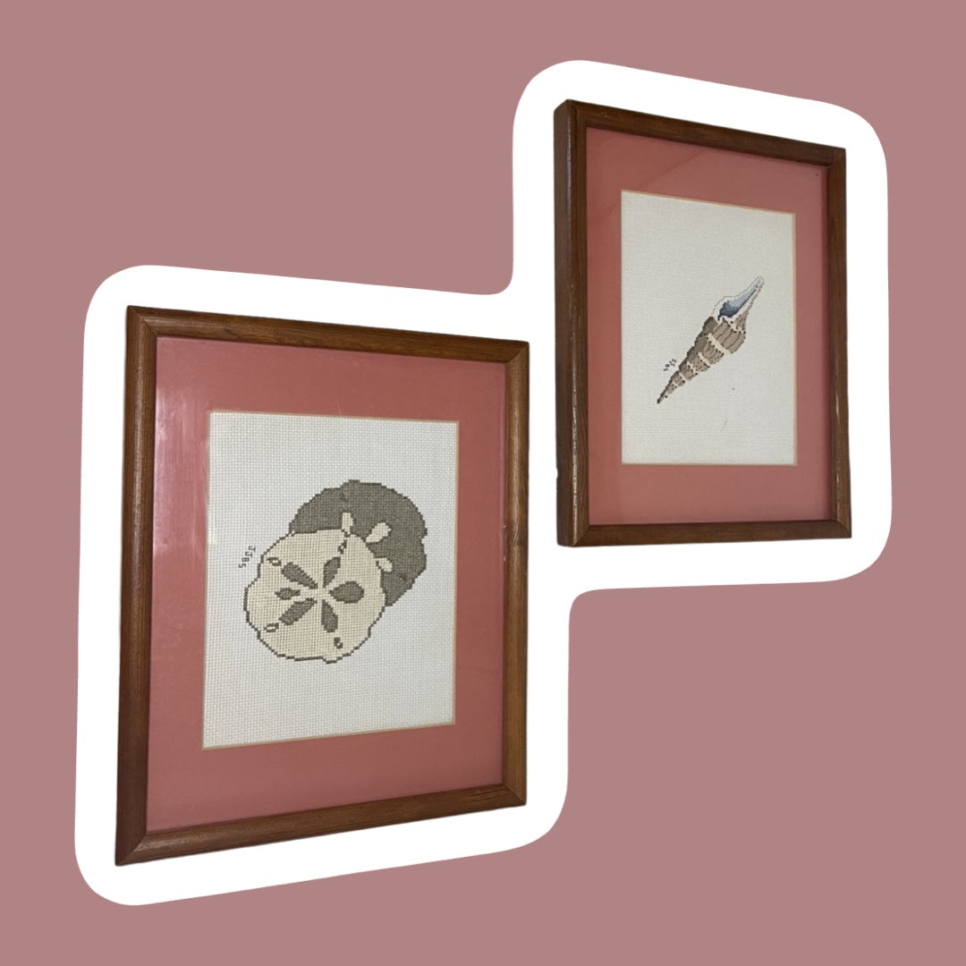 Juego de 2 obras de arte enmarcadas en rosa pastel con forma de concha marina y dólar de arena para punto de cruz
