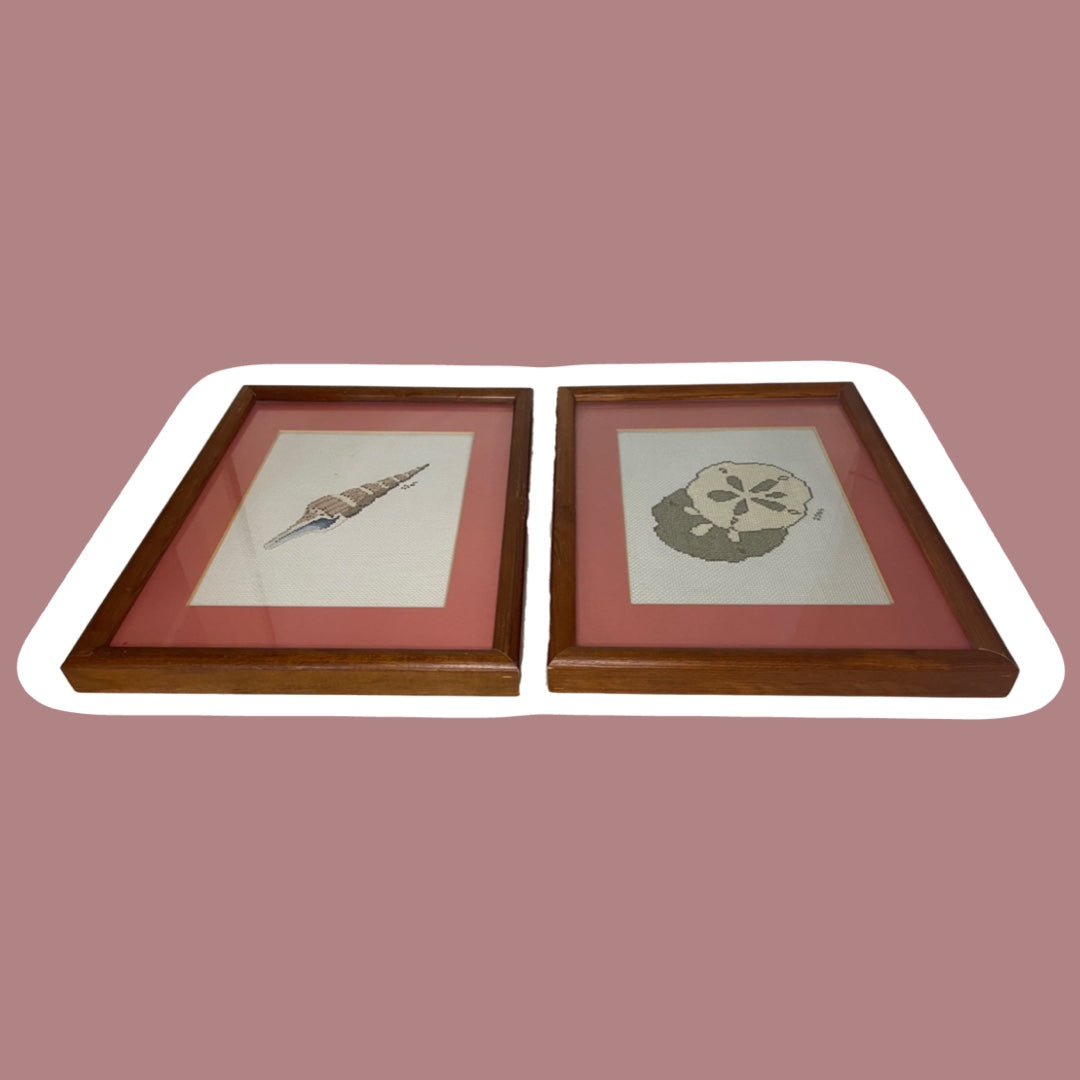Juego de 2 obras de arte enmarcadas en rosa pastel con forma de concha marina y dólar de arena para punto de cruz