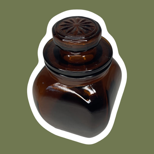 Frasco de boticario de vidrio ámbar oscuro de los años 1960 y 1970 con tapa con diseño de flores y estrellas
